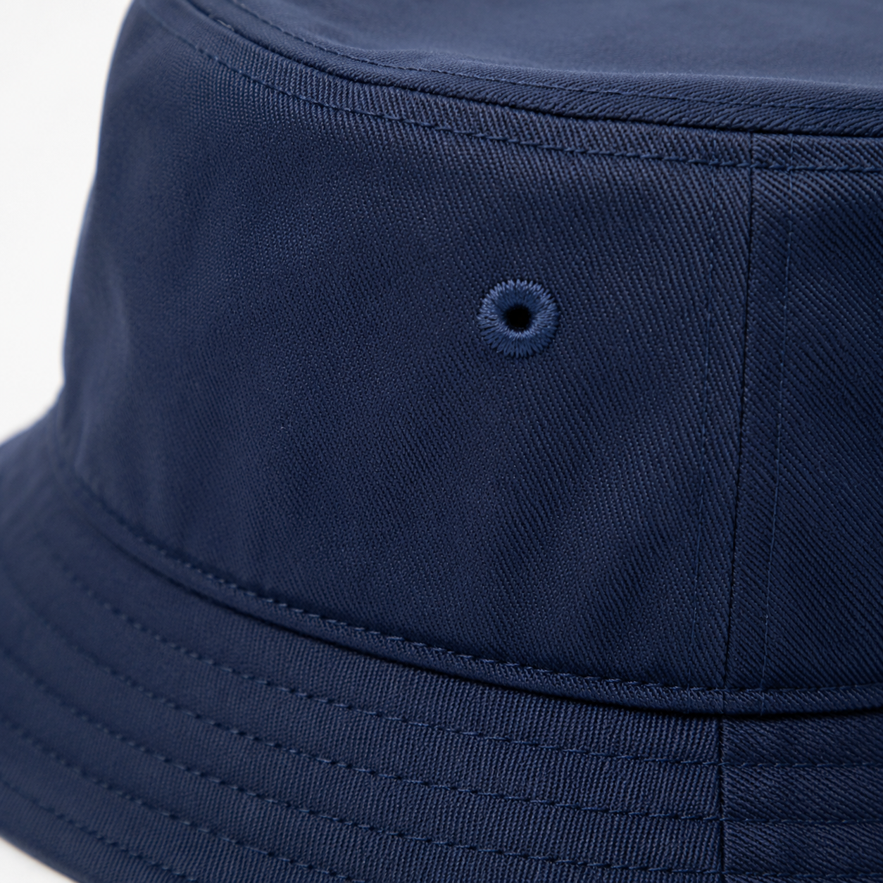 Bucket hat embroidered logo and fabric texture close-up for wholesale inspection