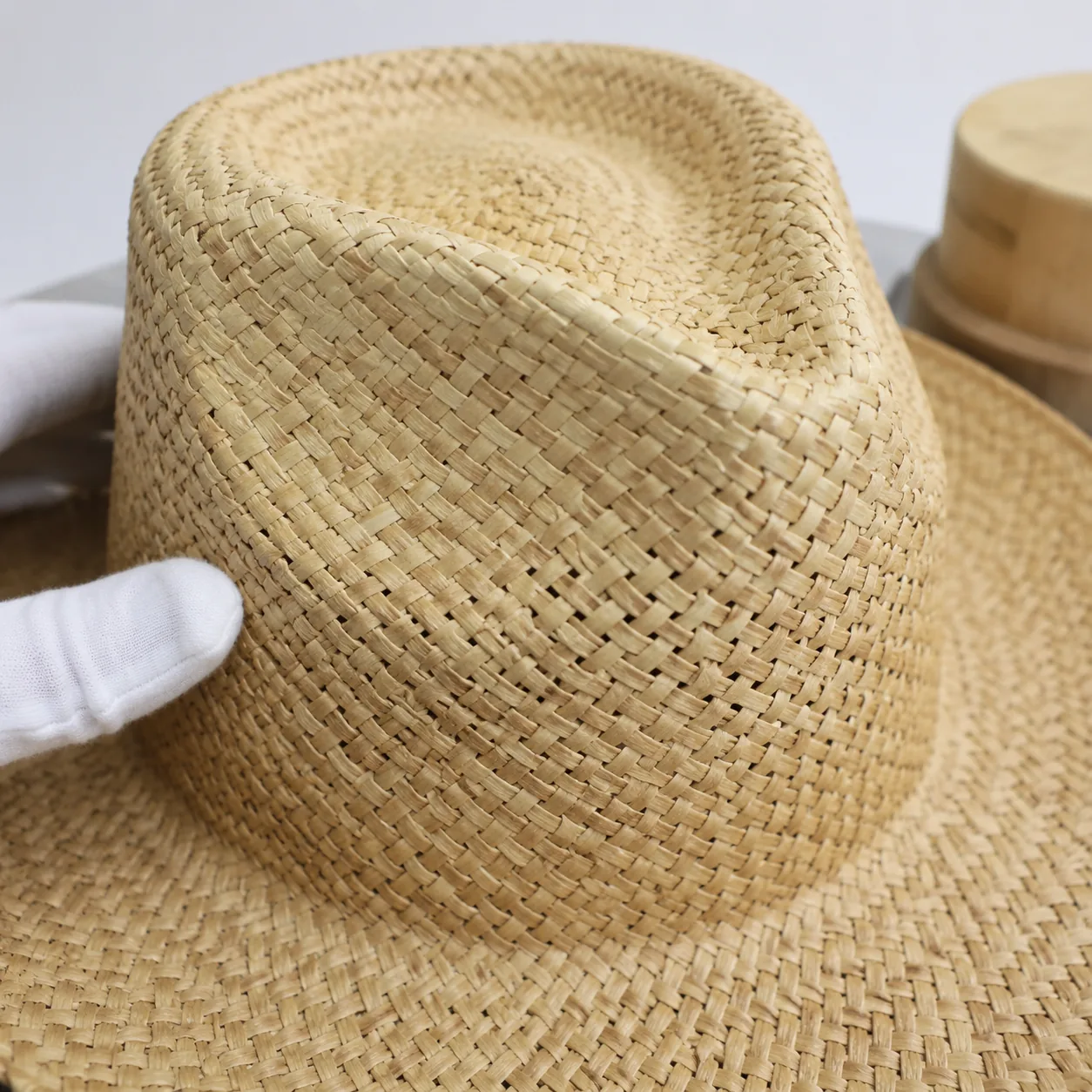 Straw hat crown blocking process on heated form for shape retention in wholesale manufacturing